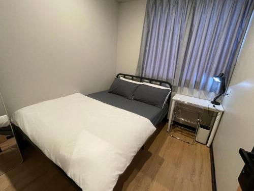 a small bedroom with a bed and a window at 22 Hours Hostel in Kampong Gadong