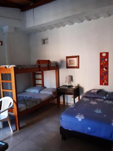 a bedroom with two bunk beds and a desk at Casa Hostal Arena de Mar in Necoclí