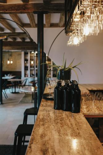 une table dans un restaurant avec des verres et des lustres dans l'établissement La Planque en Perche, à Bellou-le-Trichard