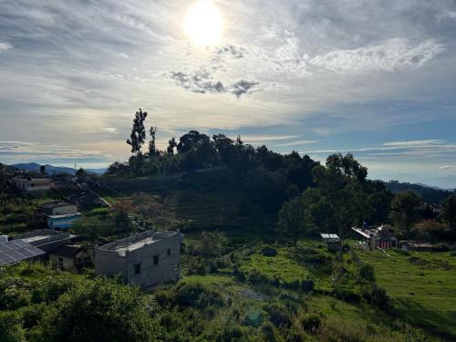 a view of a hill with the sun in the sky at VGR-HOMESTAY in Kodaikānāl
