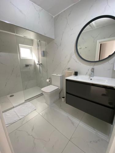 a bathroom with a sink and a toilet and a mirror at Seaside Apartment in Gzira in Il-Gżira