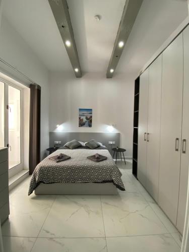 a bedroom with a bed in a white room at Seaside Apartment in Gzira in Il-Gżira