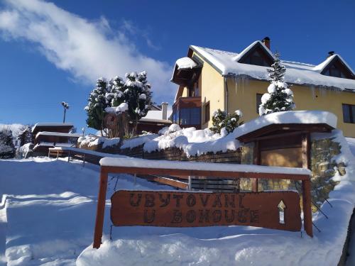 a sign in the snow in front of a house at Ubytování U Bohouše in Jilemnice