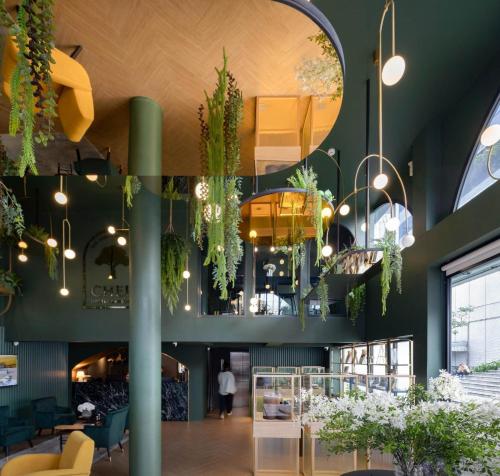 a lobby with plants hanging from the ceiling at Cher Hostel Bangkok in Bangkok