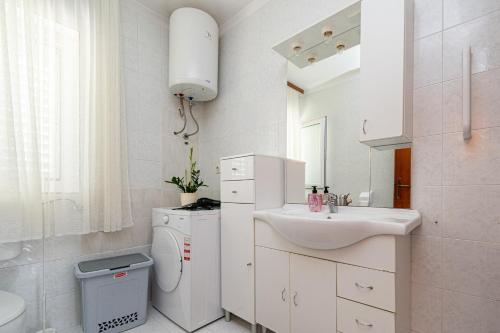 ein weißes Bad mit einem Waschbecken und einem WC in der Unterkunft Seaside holiday house Preko, Ugljan - 18077 in Preko