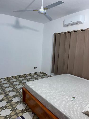 um quarto com uma cama e uma ventoinha de tecto em Agimhote 
