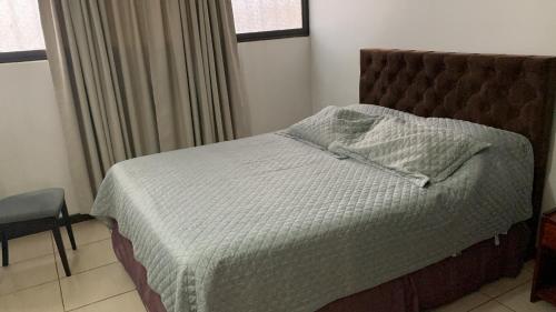 um quarto com uma cama, uma cadeira e uma janela em Céntrico y amoblado en Arica em Arica