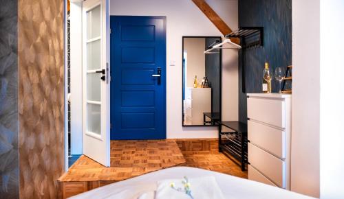 ein Badezimmer mit einer blauen Tür und einem Spiegel in der Unterkunft Naturální vinařství Tomáš Křížek, Penzion Dvorek in Dolní Dunajovice