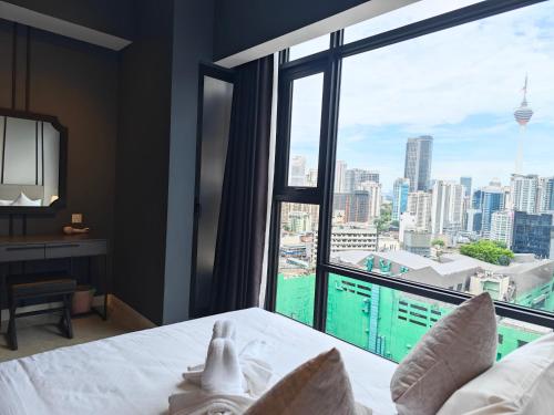 a bedroom with a bed and a large window at Axon Residences Bukit Bintang in Kuala Lumpur