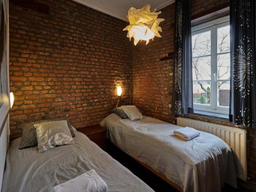 a bedroom with two beds and a brick wall at Lovely Apartment in Mesch with Parking in Mesch