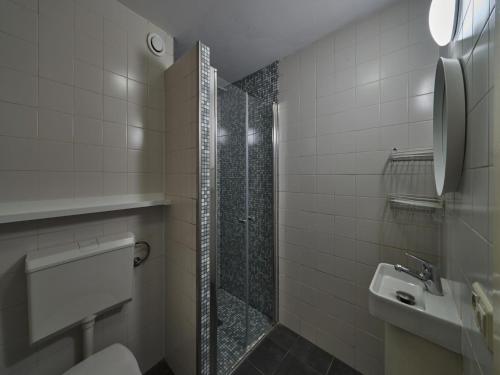 uma casa de banho com um chuveiro, um WC e um lavatório. em Spacious Apartment near Town Center in Mesch em Mesch