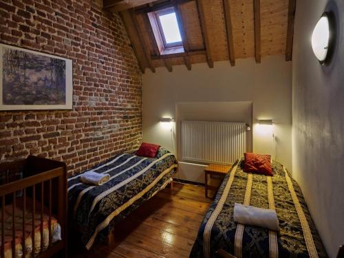 Cette chambre comprend 2 lits et un mur en briques. dans l'établissement Spacious Apartment near Town Center in Mesch, à Mesch