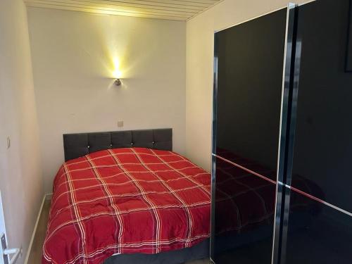 a bedroom with a bed with a red blanket at Vakantie appartement Limburg in Maaseik