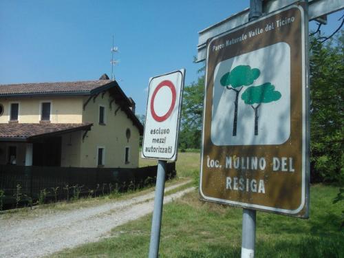 a sign with trees on it next to a dirt road at Agriturismo Helianthus in Oleggio