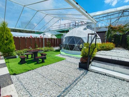 a garden with a greenhouse and a picnic table at Glamz Hills in Cameron Highlands