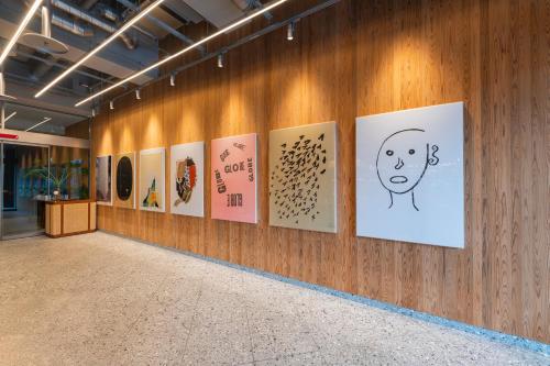 a hallway with paintings on a wooden wall at THE KNOT HIROSHIMA in Hiroshima