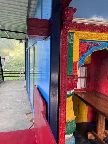 a colorful wall of a building with a wooden bench at Shoonya Home Stay - Devalsari Deodar Forest Range - 60min from Mussoorie in Mussoorie