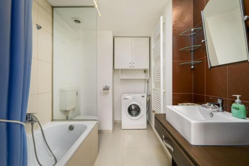 a bathroom with a sink and a washing machine at Chrysoprase Apartment in Budapest