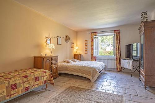 - une chambre avec 2 lits, une télévision et une fenêtre dans l'établissement Villa de Minna, à Robion