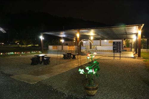 a pavilion with a table and benches at night at Bee Good Chalet in Yan