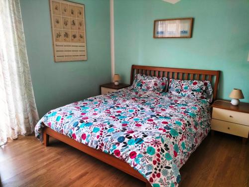 - une chambre avec un lit et une couette à fleurs dans l'établissement Maison Hèléne, à Aoste