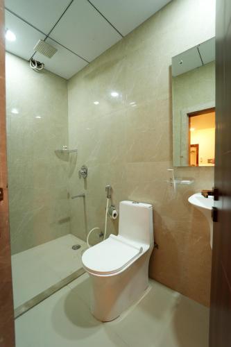 a bathroom with a toilet and a shower and a sink at Mevid Hotels in Hyderabad