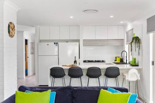 a living room with a blue couch and a kitchen at Busselton Family Holiday House - by the Bay in Geographe