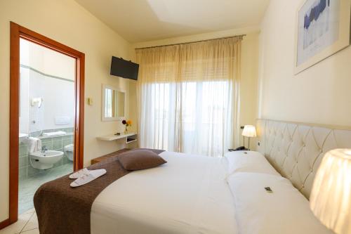 a hotel room with a large bed and a bathroom at Hotel Nuova Sabrina in Marina di Pietrasanta