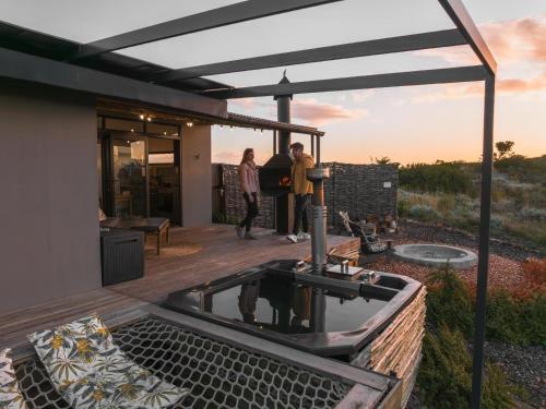 two people standing on a patio with a hot tub at Aviary Hills Luxury Hideaway in Heidelberg