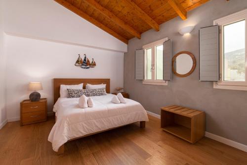 a bedroom with a large bed and a mirror at Andros 4 All Seasons Villas & Suites in Andros