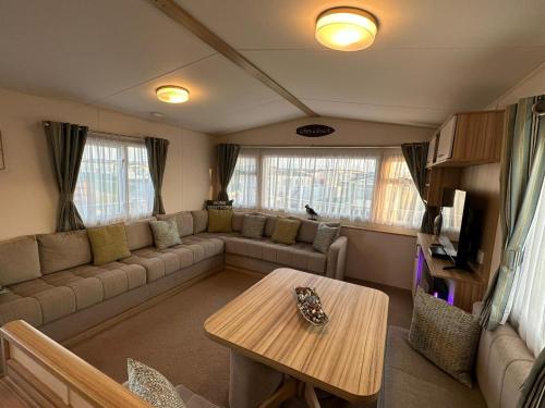 a living room with a couch and a table at Beach life in Lossiemouth