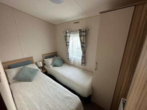 a small bedroom with two beds and a window at Beach life in Lossiemouth