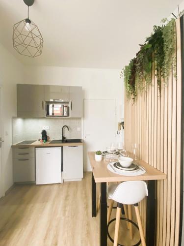 une cuisine avec une table en bois et une table et des chaises dans l'établissement Studio sur le Port de St Gilles Croix de Vie, à Saint-Gilles-Croix-de-Vie