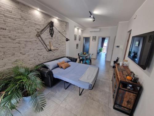 uma sala de estar com um sofá e uma parede de tijolos em Studi011 slow travel em Turim