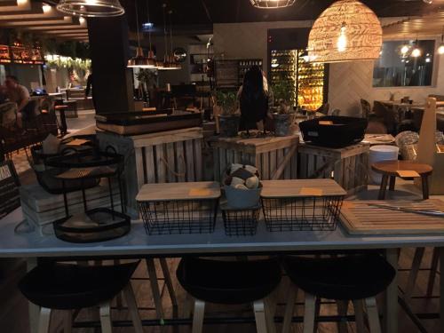 a table with stools and tables in a restaurant at Novotel Valence Sud in Valence