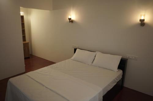 a small bedroom with a bed with two pillows at Marari Red Angel in Mararikulam