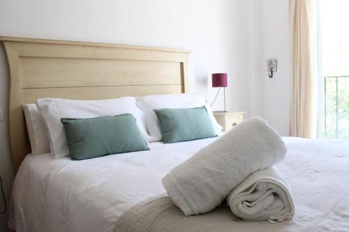 ein weißes Bett mit zwei Kissen und einem Handtuch darauf in der Unterkunft Casa Rural La Senda de Aroche in Aracena