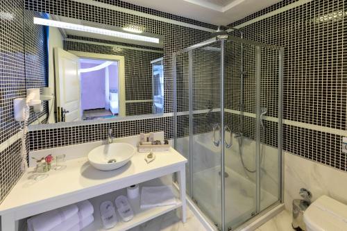 a bathroom with a sink and a glass shower at Viento Alacati Hotel in Alacati