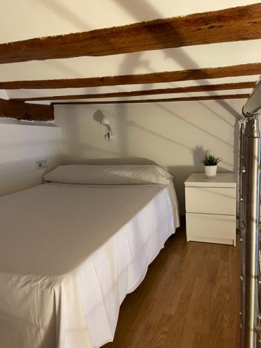 a bedroom with a white bed and a wooden floor at Espectacular Estudio en Antigua Casa de Correos in Molina de Aragón