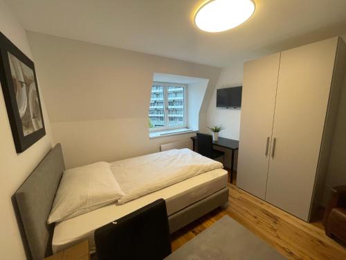 um pequeno quarto com uma cama e uma janela em SCHNYDER'S HOME - Studio_1 em Rapperswil-Jona