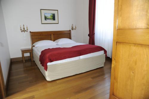 a bedroom with a large bed with a red blanket at Hapimag Château de Chabenet in Chabenet