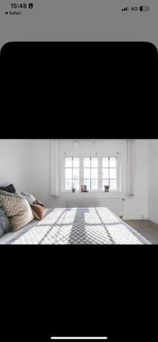 a white room with a bed and two windows at Toarp Inn in Malmö