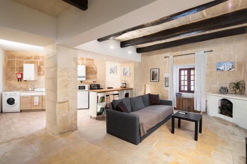 un soggiorno con divano e una cucina di Lapsi Apartments - Traditional Maltese Style near the Promenade a San Giuliano