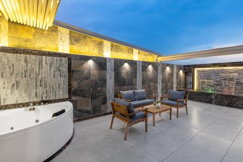 a bathroom with a tub and a table and chairs at Faraj Almadina Hotel in Medina