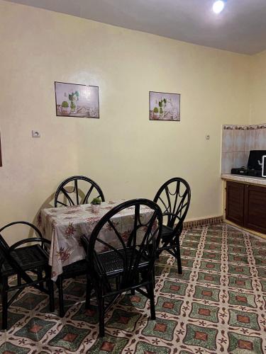 a dining room with a table and four chairs at Dar Diyafa in El Ksiba