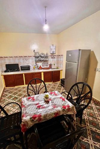 kuchnia ze stołem, krzesłami i lodówką w obiekcie Dar Diyafa w mieście El Ksiba