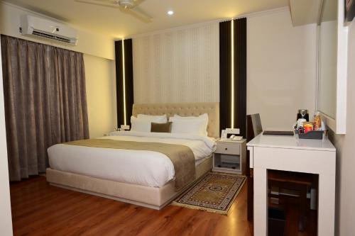 Un dormitorio con una cama y un escritorio con una computadora. en Hotel Amayra, en Jaipur