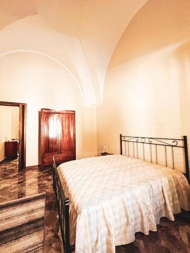 a bedroom with a large bed in a room at Maison Li Signuri in Maglie