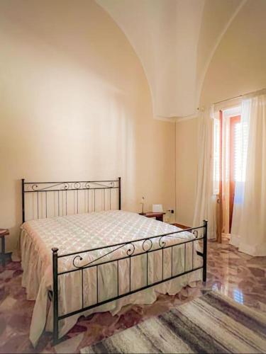 a bedroom with a bed in a room with a window at Maison Li Signuri in Maglie