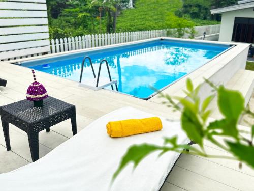 a table with a yellow towel on it next to a swimming pool at Baan Pila in Luang Prabang